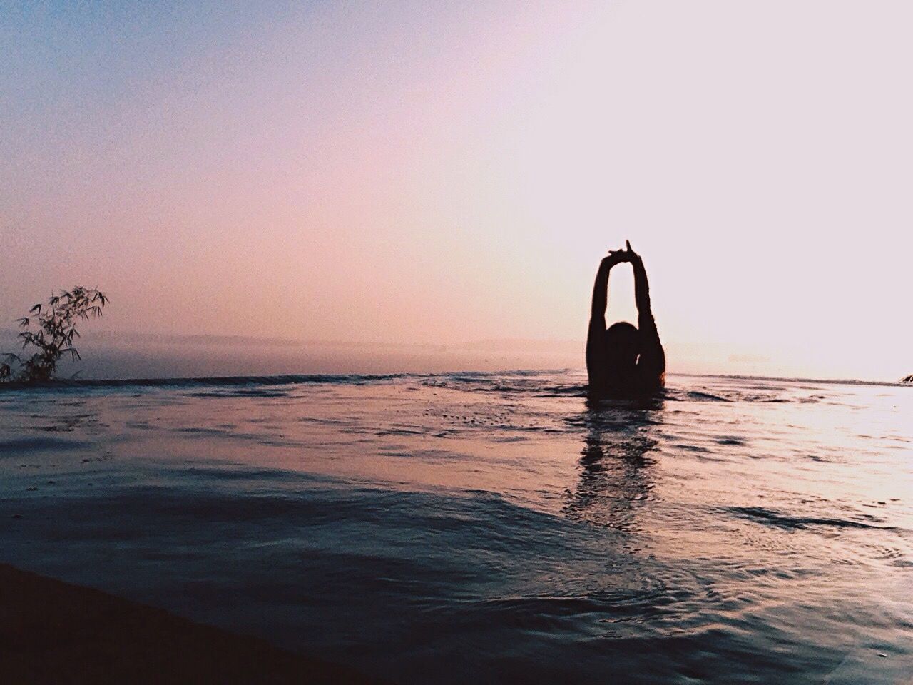 Silhouette person swimming in pool against sky during sunset