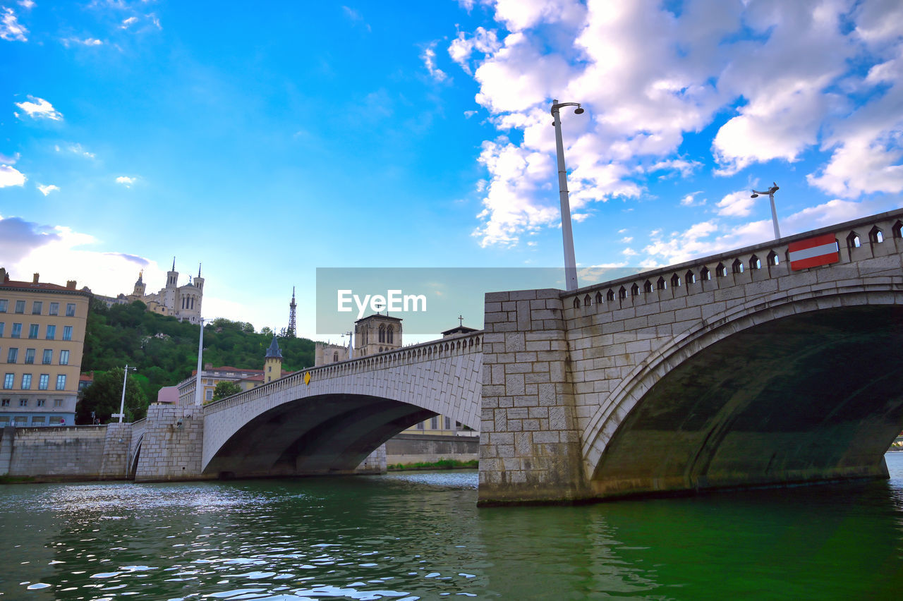 ARCH BRIDGE OVER RIVER IN CITY AGAINST SKY