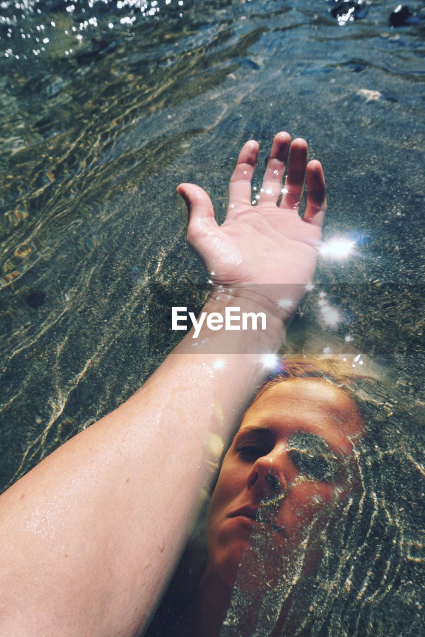 Double exposure portrait of woman and hand in water