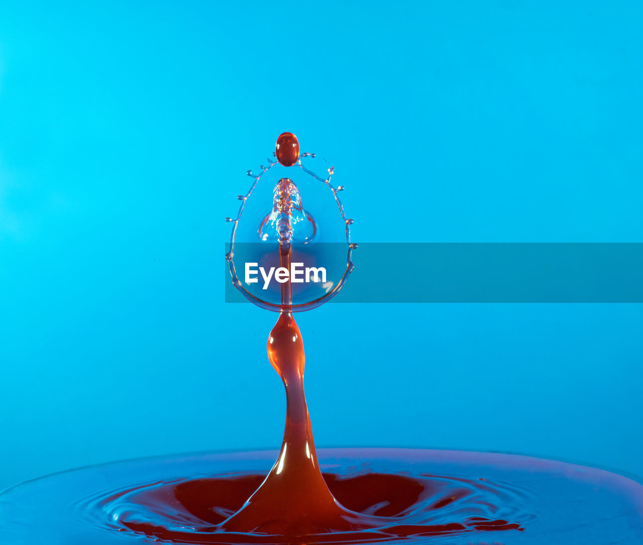 Close up of liquid splashing against blue background