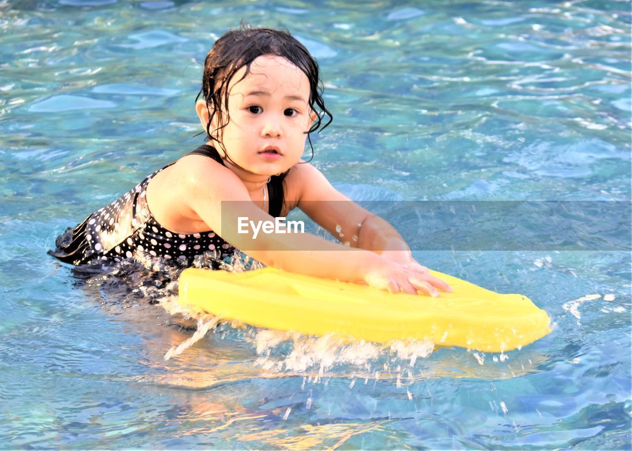 FULL LENGTH OF SHIRTLESS BOY SWIMMING IN WATER