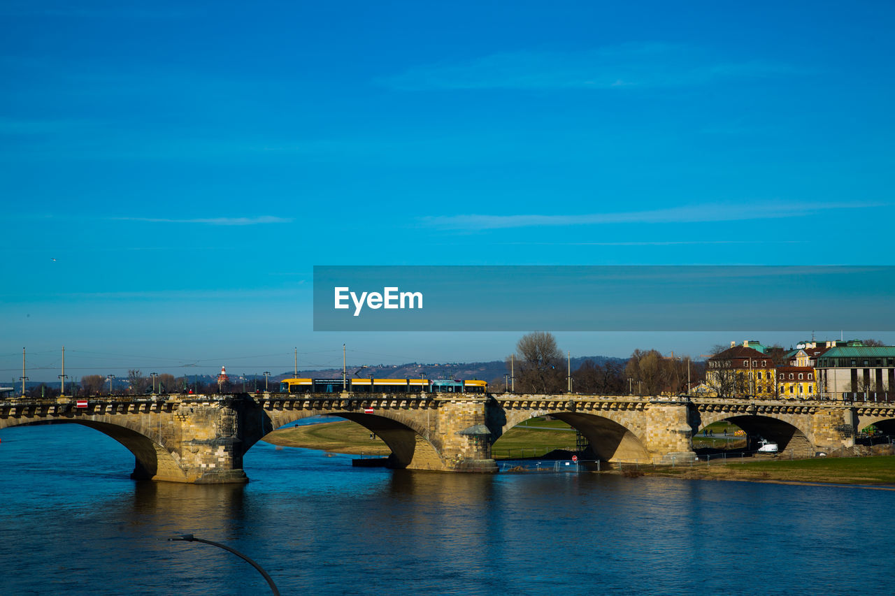 bridge, architecture, built structure, water, arch, arch bridge, sky, transportation, reflection, dusk, city, river, travel destinations, nature, building exterior, blue, evening, no people, travel, cityscape, horizon, cloud, landmark, aqueduct, waterfront, history, tourism, outdoors, night, the past, illuminated