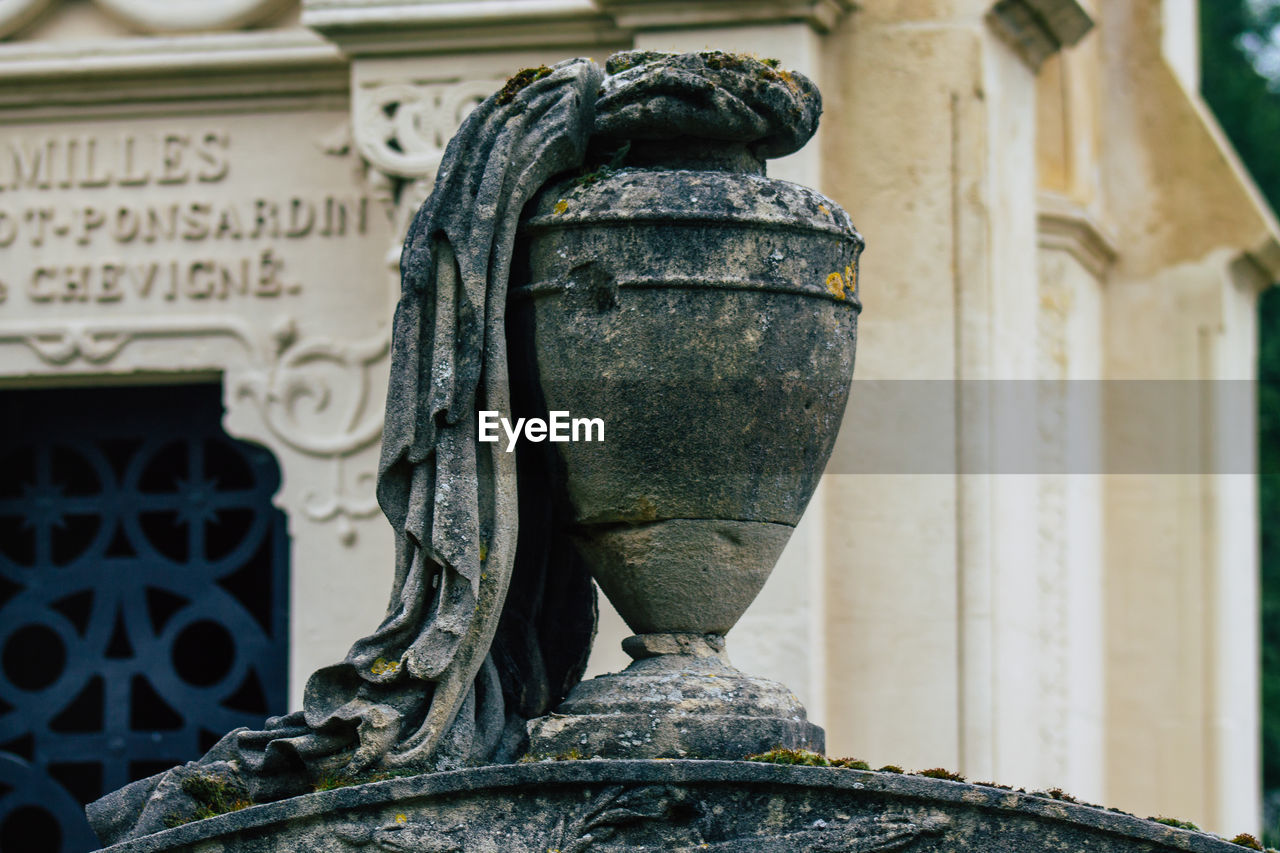 CLOSE-UP OF OLD SCULPTURE ON BUILDING