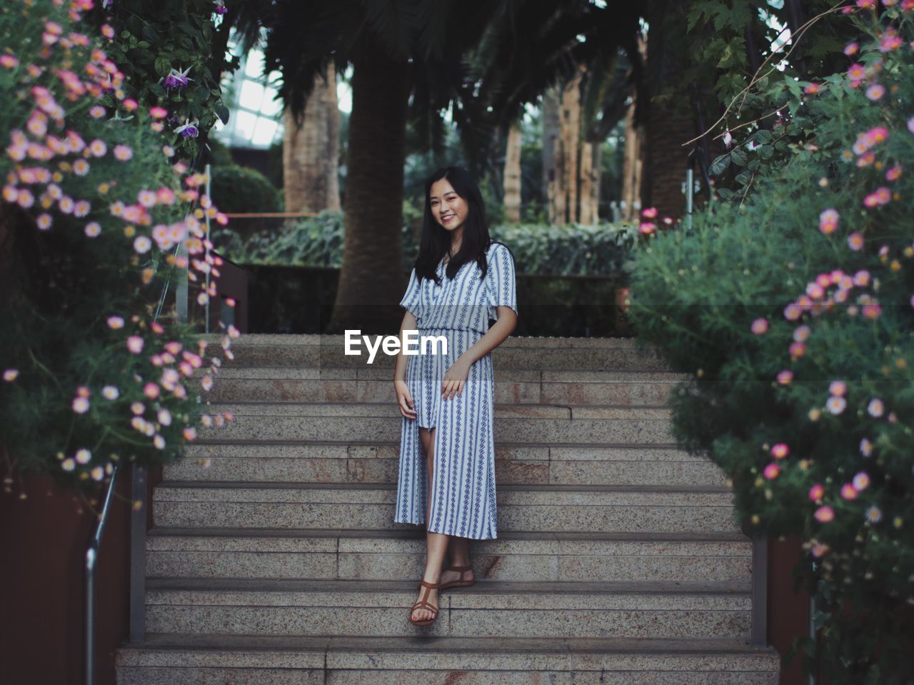 Portrait of young woman standing on steps