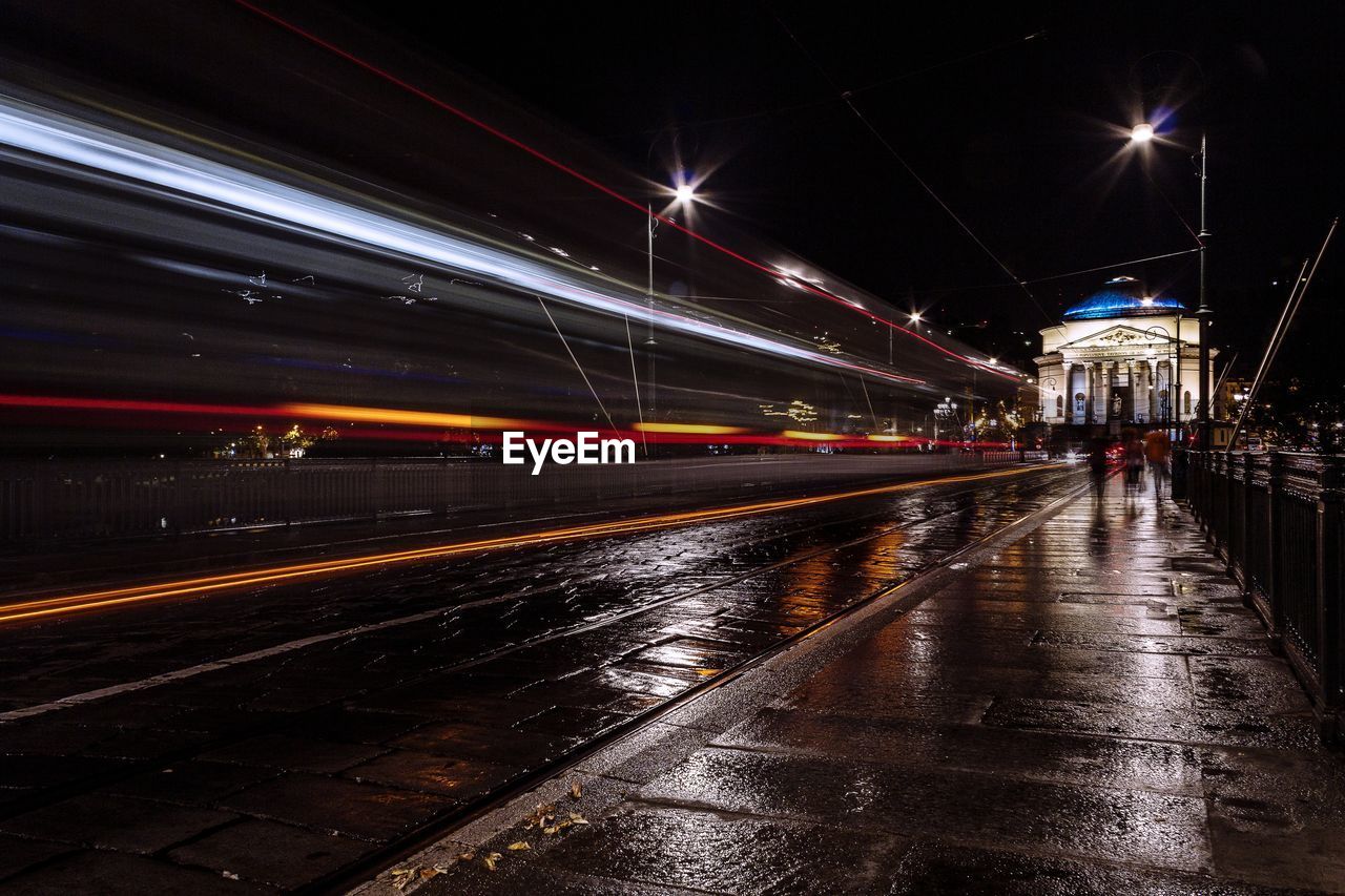 Light trails on road against sky at night