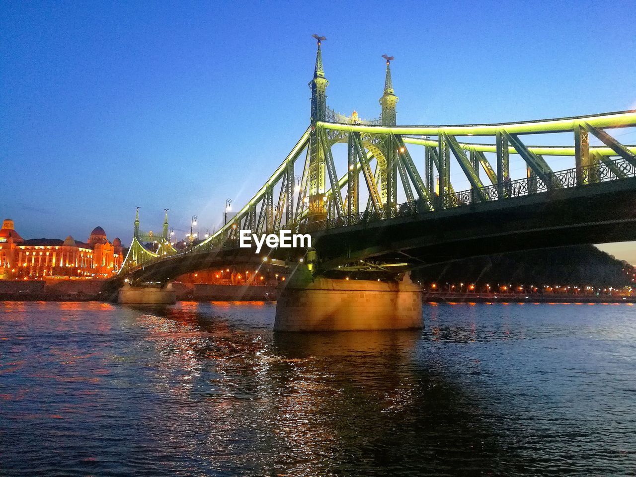 BRIDGE OVER RIVER AGAINST BLUE SKY WITH WATERFRONT