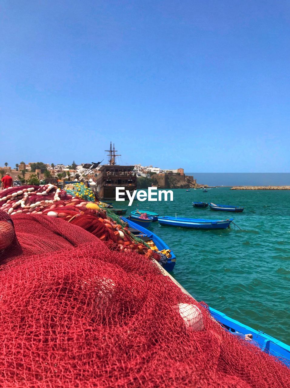 BOATS MOORED ON SEA AGAINST CLEAR SKY