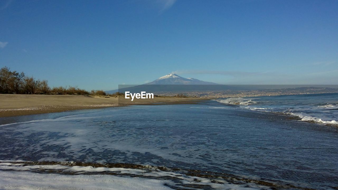 SCENIC VIEW OF SEA AND MOUNTAIN AGAINST CLEAR BLUE SKY