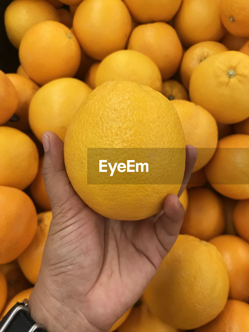 Cropped hand holding lemon at market