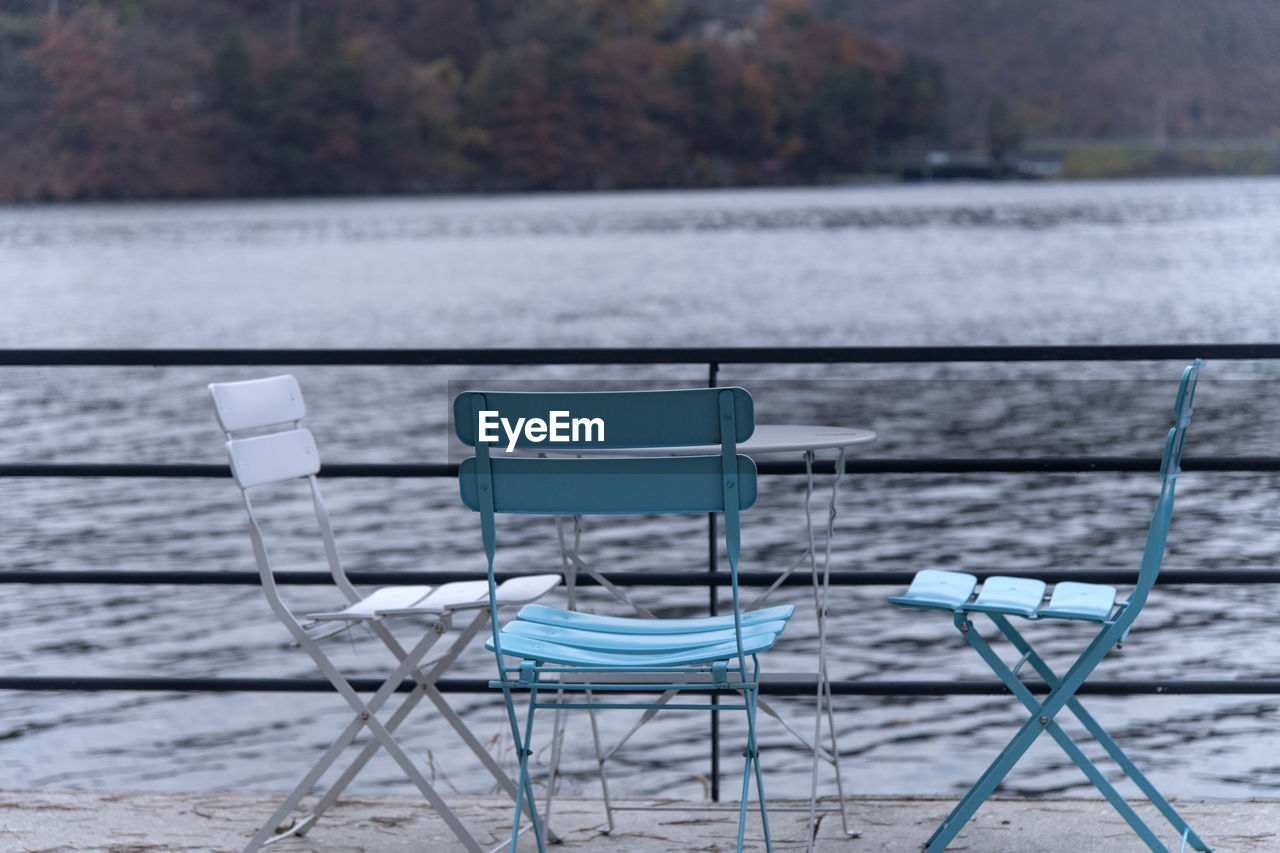 Empty chairs by lake