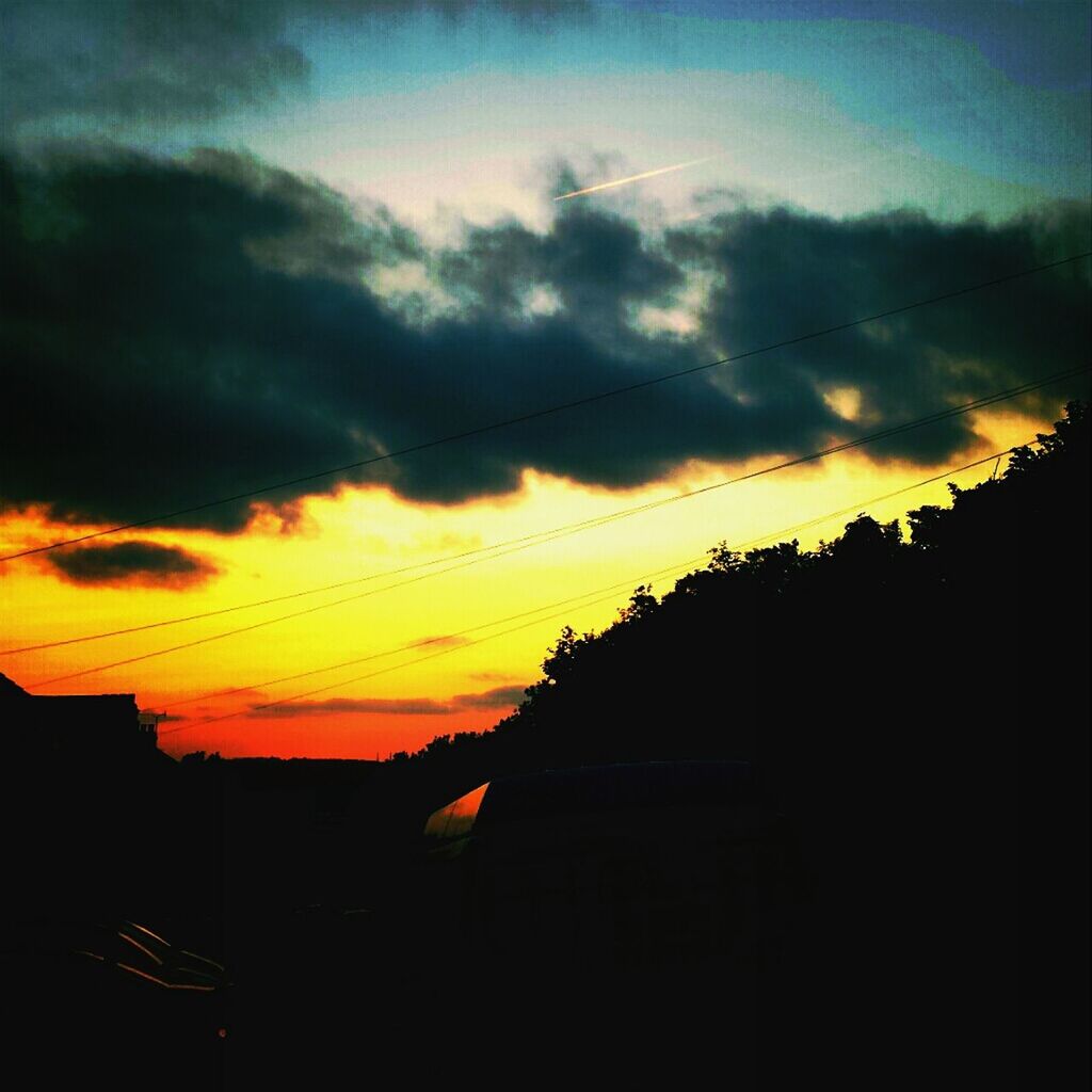 SILHOUETTE OF BUILT STRUCTURE AGAINST CLOUDY SKY