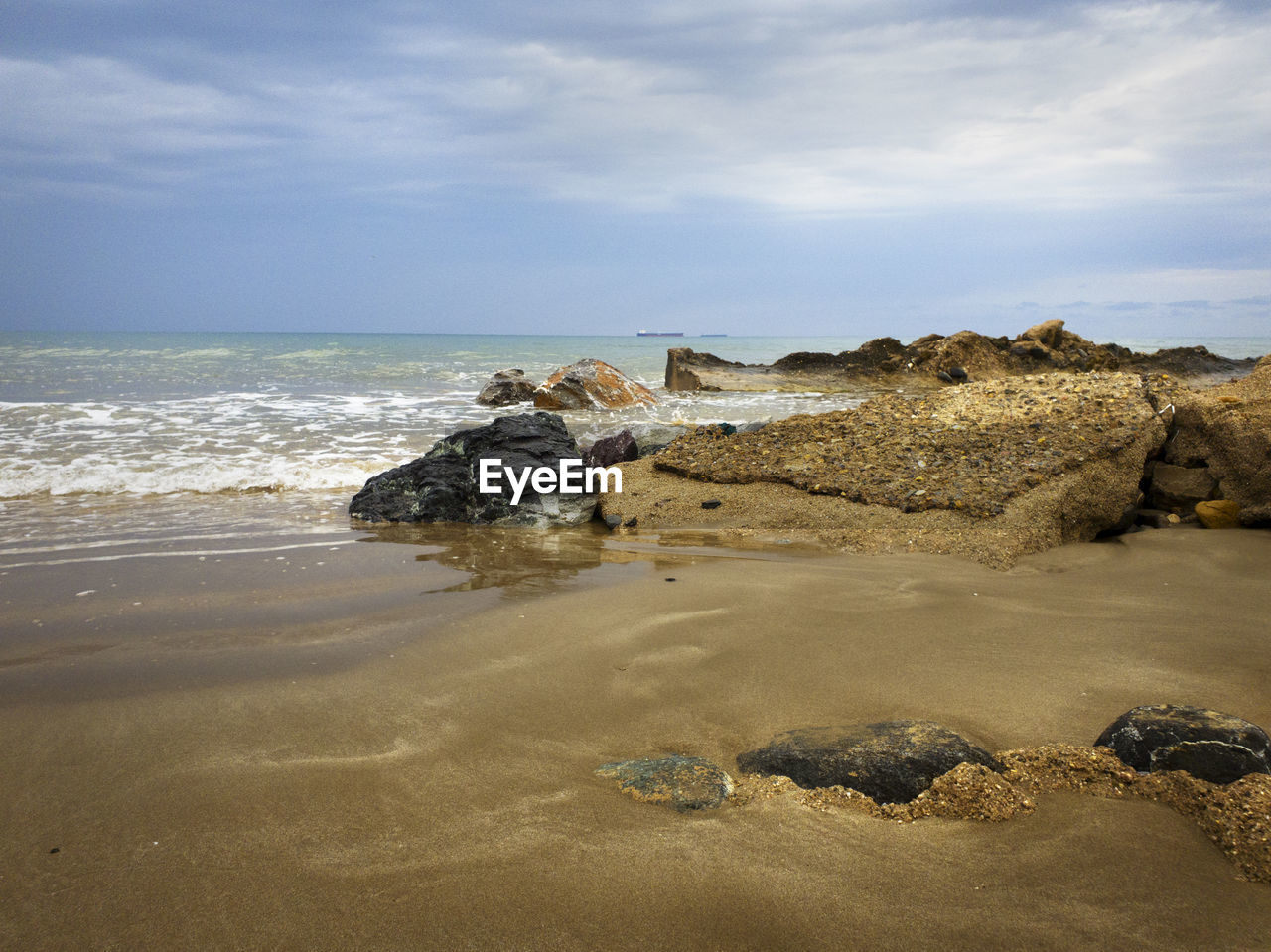 Rocks on beach against sky