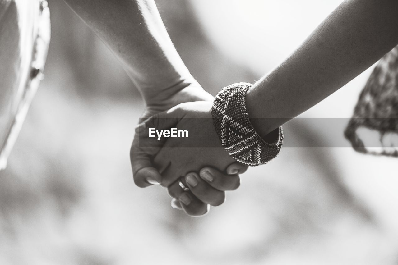 Close-up of hand holding hands against blurred background