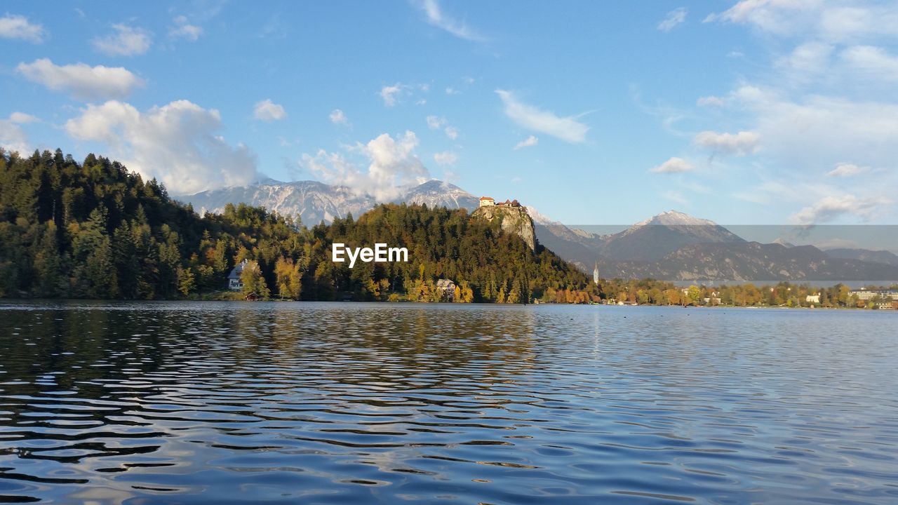 Scenic view of lake by mountains against sky