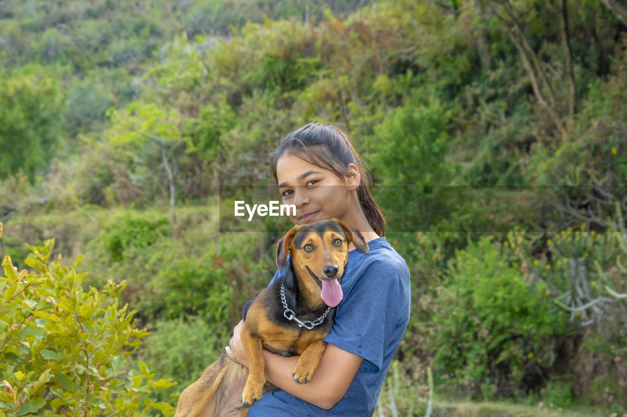 Beautiful girl playing with her pet dog in farm