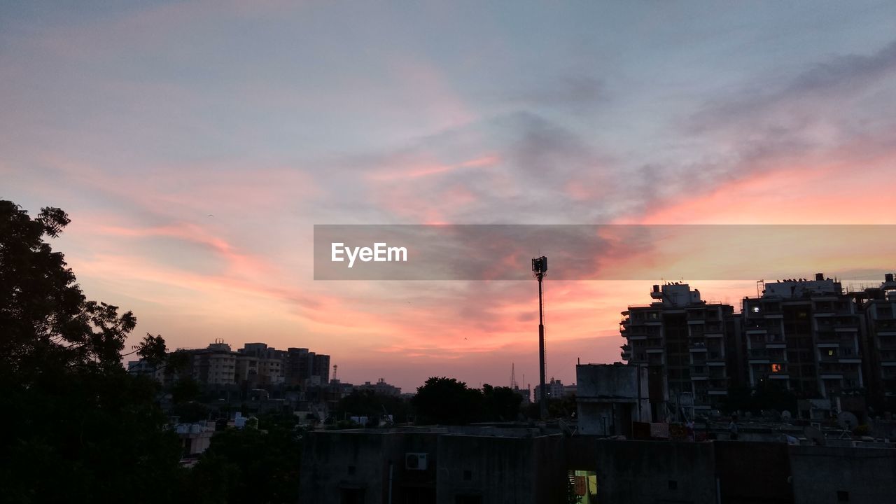 SILHOUETTE OF CITY AGAINST CLOUDY SKY