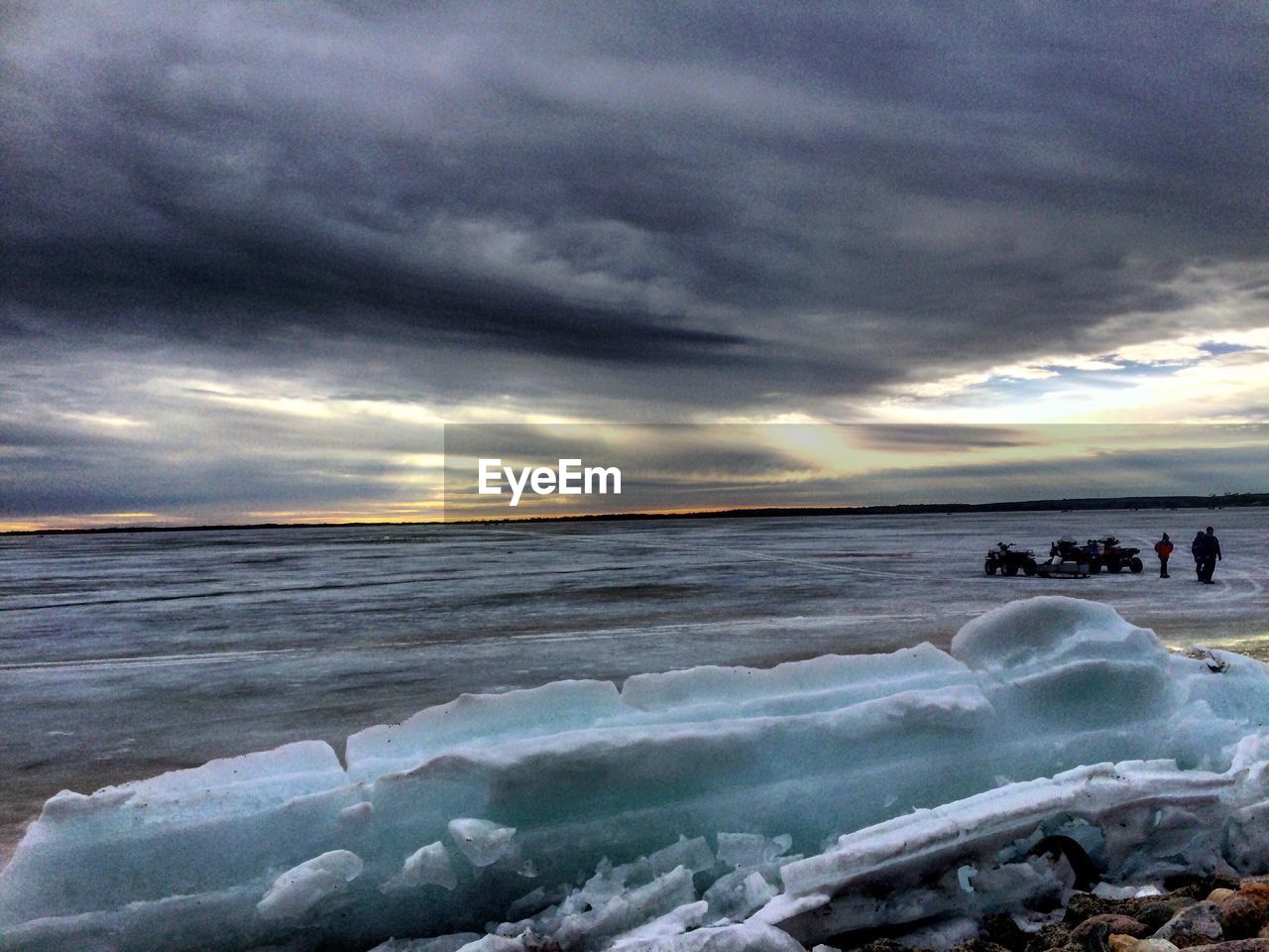 SCENIC VIEW OF FROZEN SEA AGAINST DRAMATIC SKY DURING WINTER