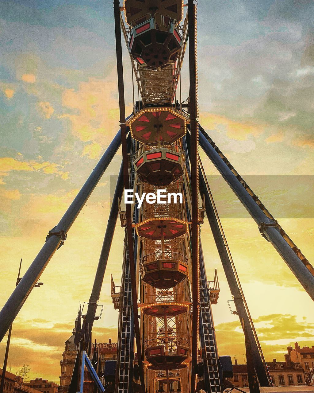 Low angle view of ferris wheel against cloudy sky