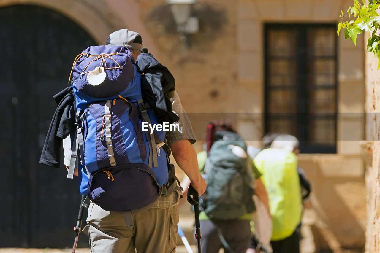 Camino de santiago  to compostela , unrecognizable pilgrims with scallop shell  in backpack