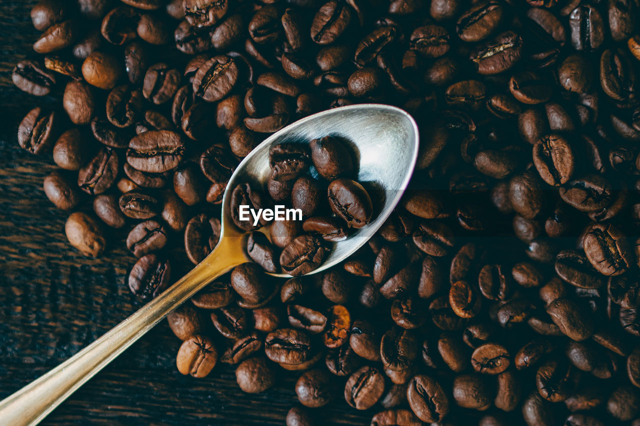 Coffee beans and spoon on table