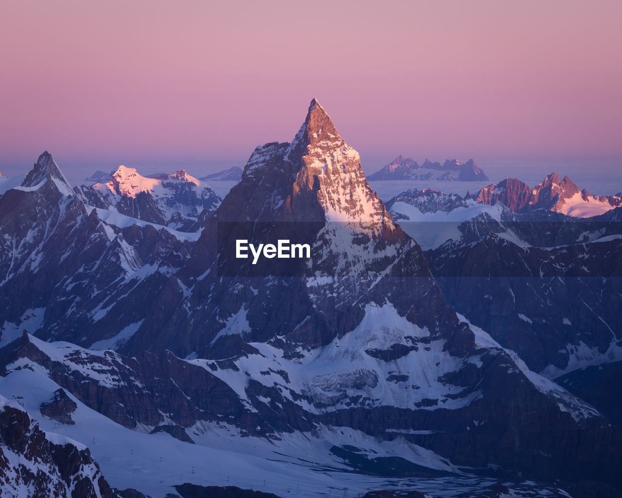 Scenic view of snowcapped mountains against sky during sunset