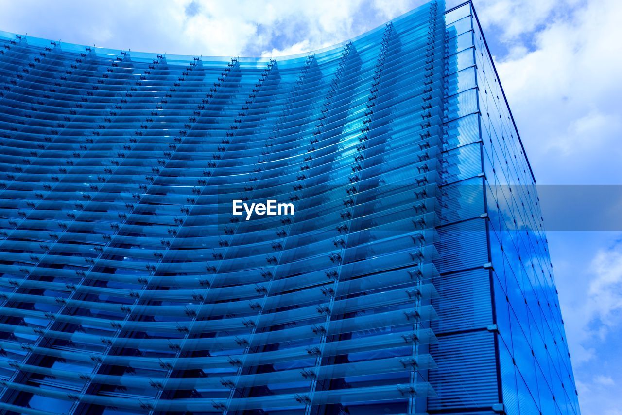 Low angle view of modern skyscraper against blue sky