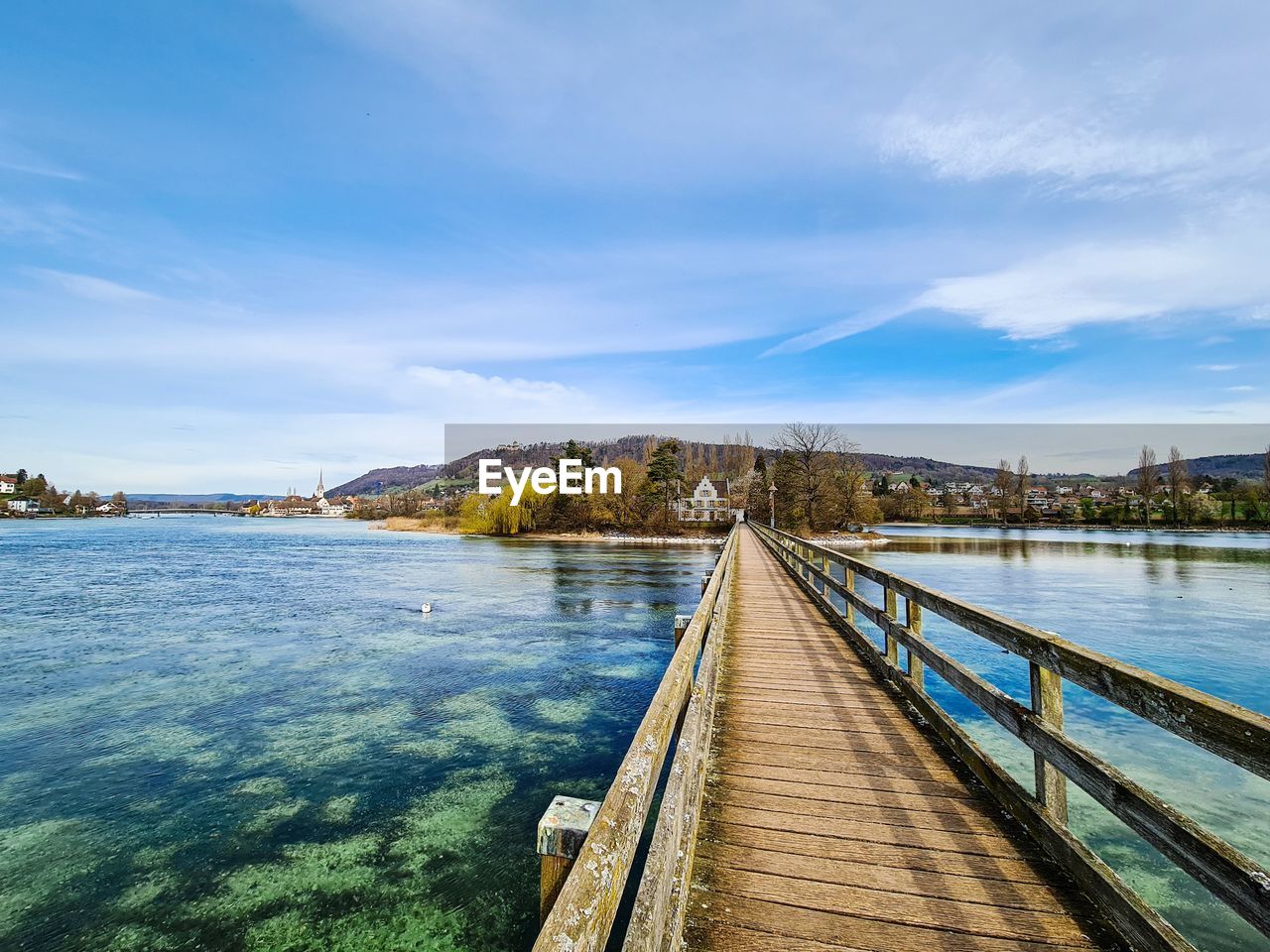 View of bridge over calm river against sky