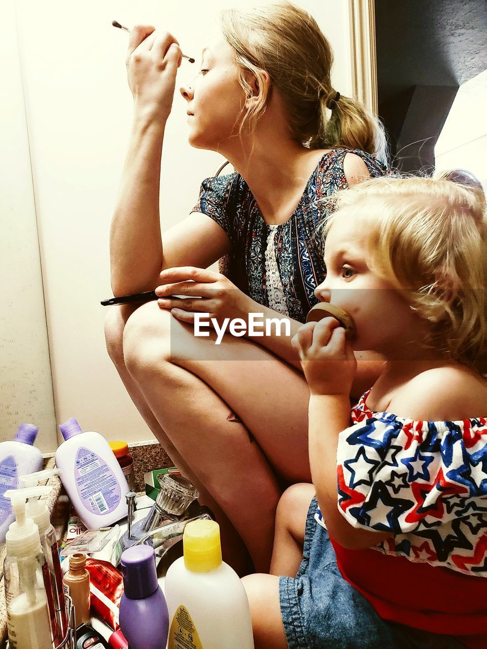 MOTHER AND DAUGHTER SITTING ON SOFA