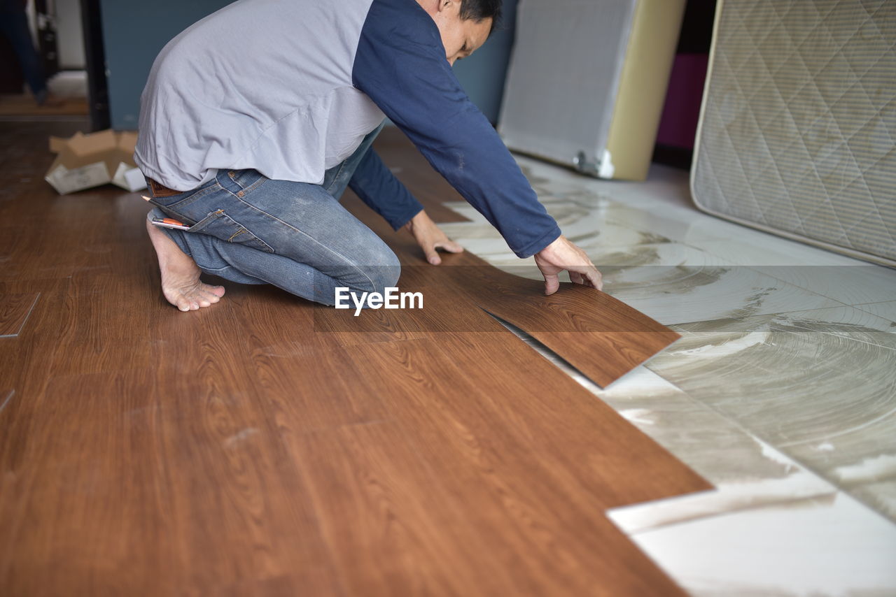 MAN WORKING ON WOODEN TABLE