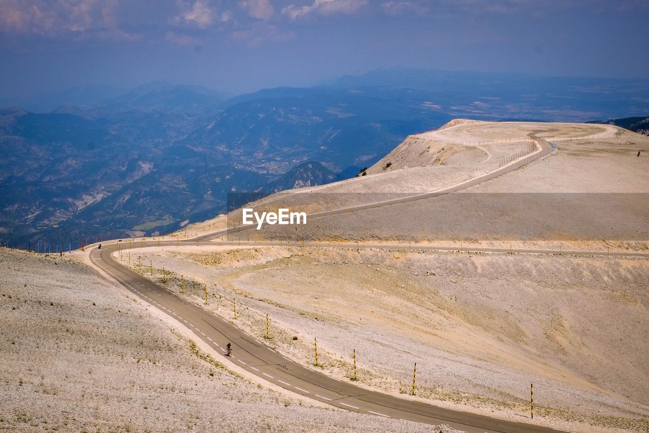 Scenic view of road by mountains against sky