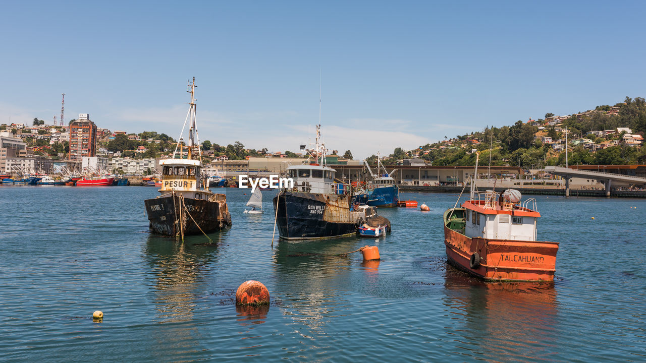 BOATS MOORED IN SEA AGAINST SKY