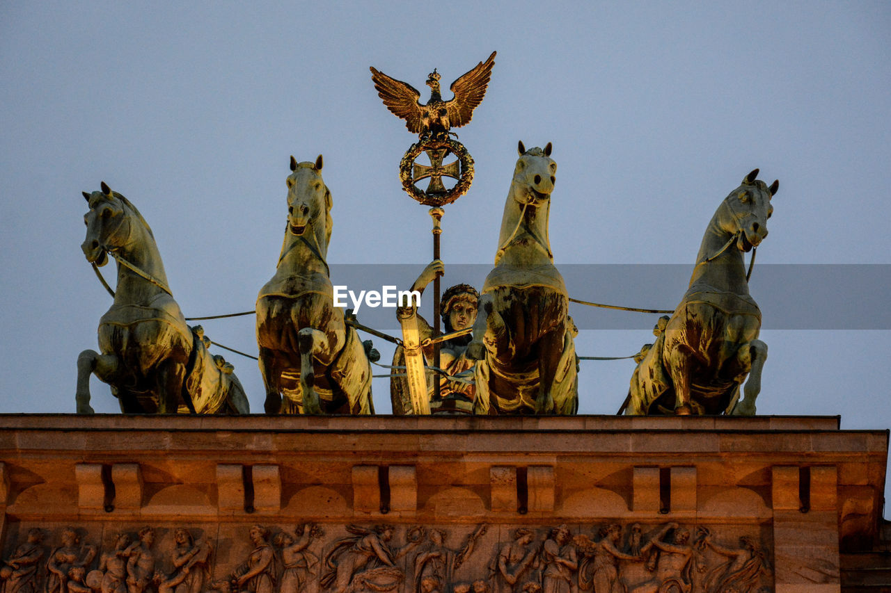 LOW ANGLE VIEW OF STATUES AGAINST CLEAR SKY