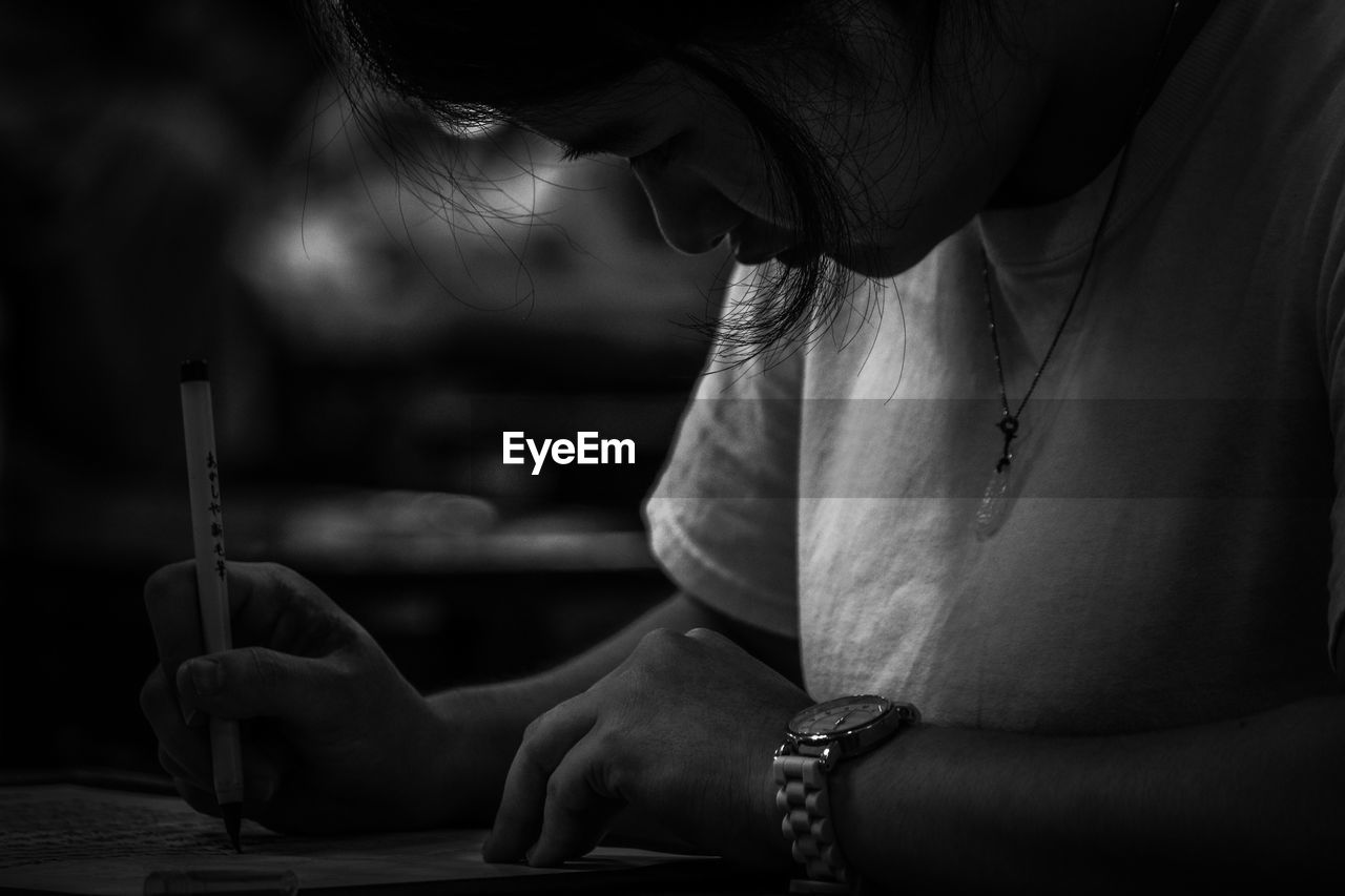 Close-up of young woman writing