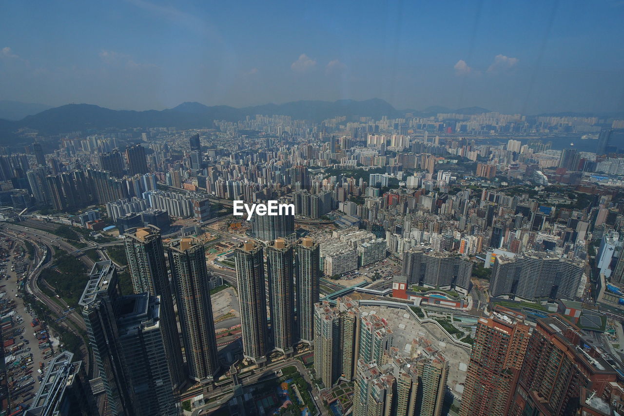 AERIAL VIEW OF ILLUMINATED CITY BUILDINGS AGAINST SKY