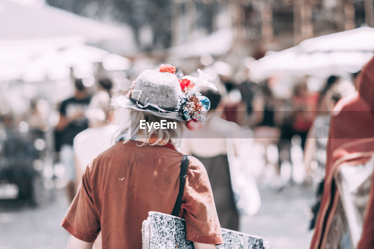 REAR VIEW OF PEOPLE WALKING ON STREET DURING WINTER