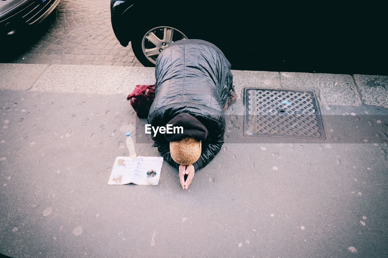 High angle view of man begging on sidewalk