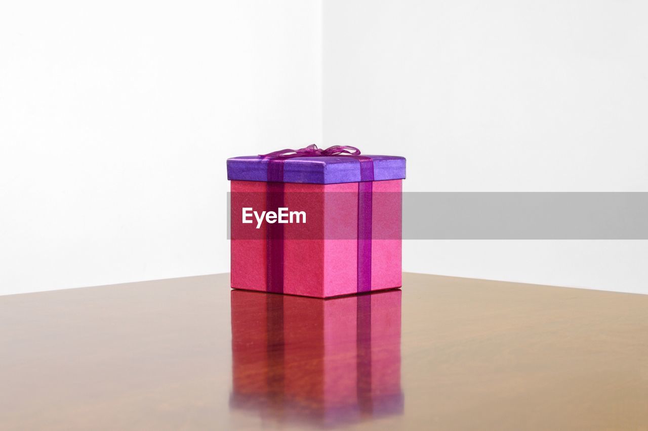 Close-up of gift box on table against white background