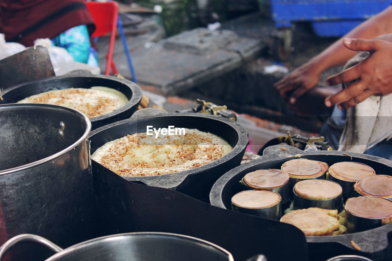 Cropped hands of vendor by peanut cakes for sale at market stall