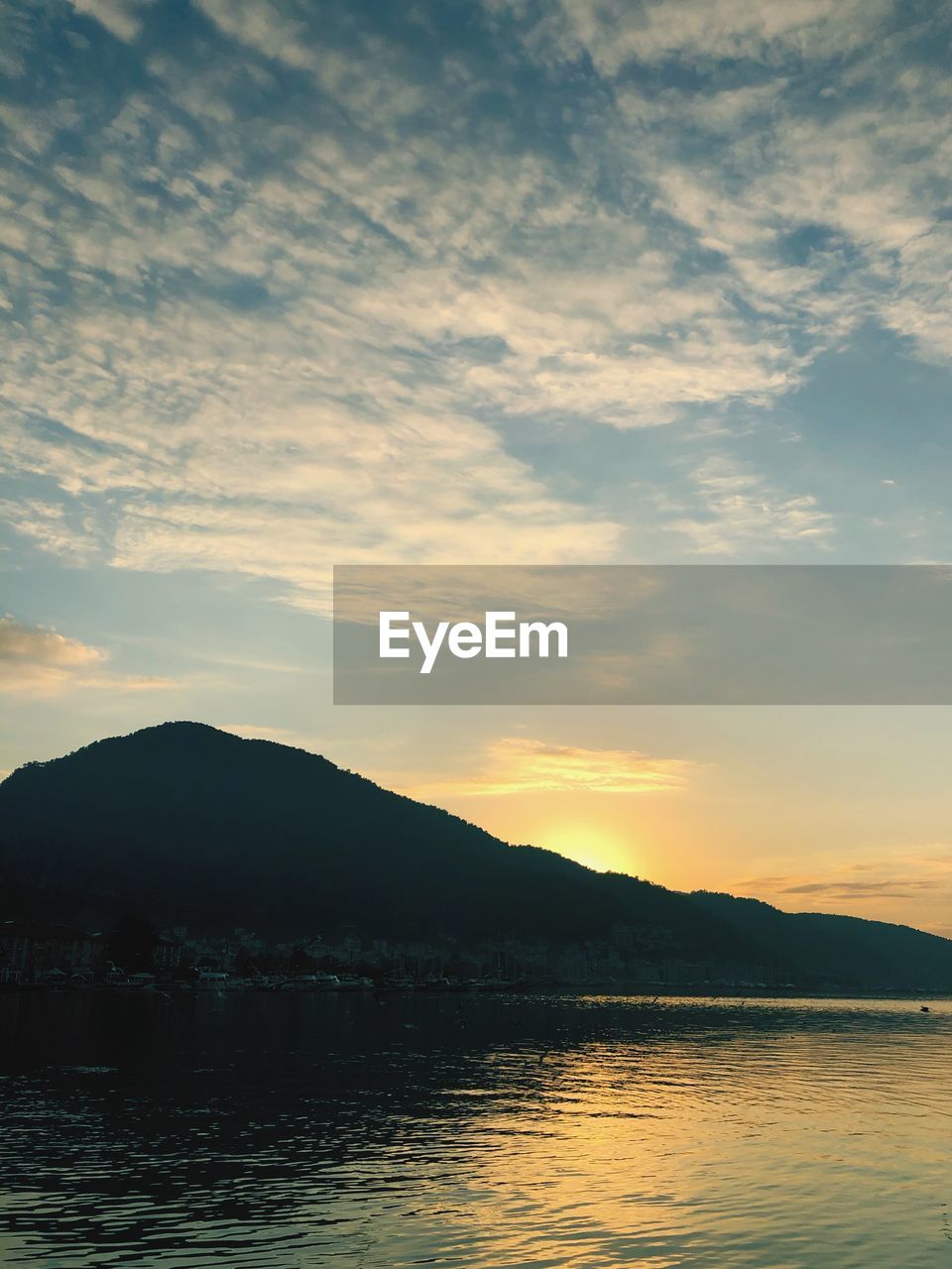 SCENIC VIEW OF SEA AND SILHOUETTE MOUNTAINS AGAINST SKY DURING SUNSET