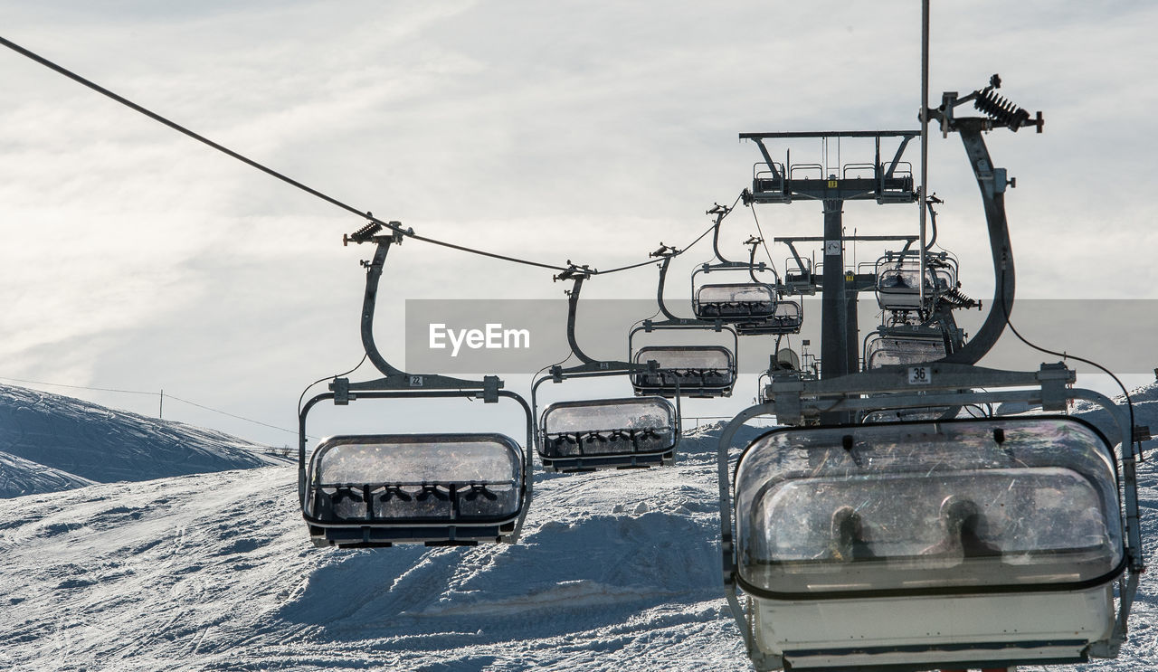 transportation, snow, vehicle, cold temperature, mode of transportation, nature, winter, cable car, ski lift, cloud, sky, no people, day, environment, travel, overhead cable car, outdoors, cable, landscape, mountain, technology