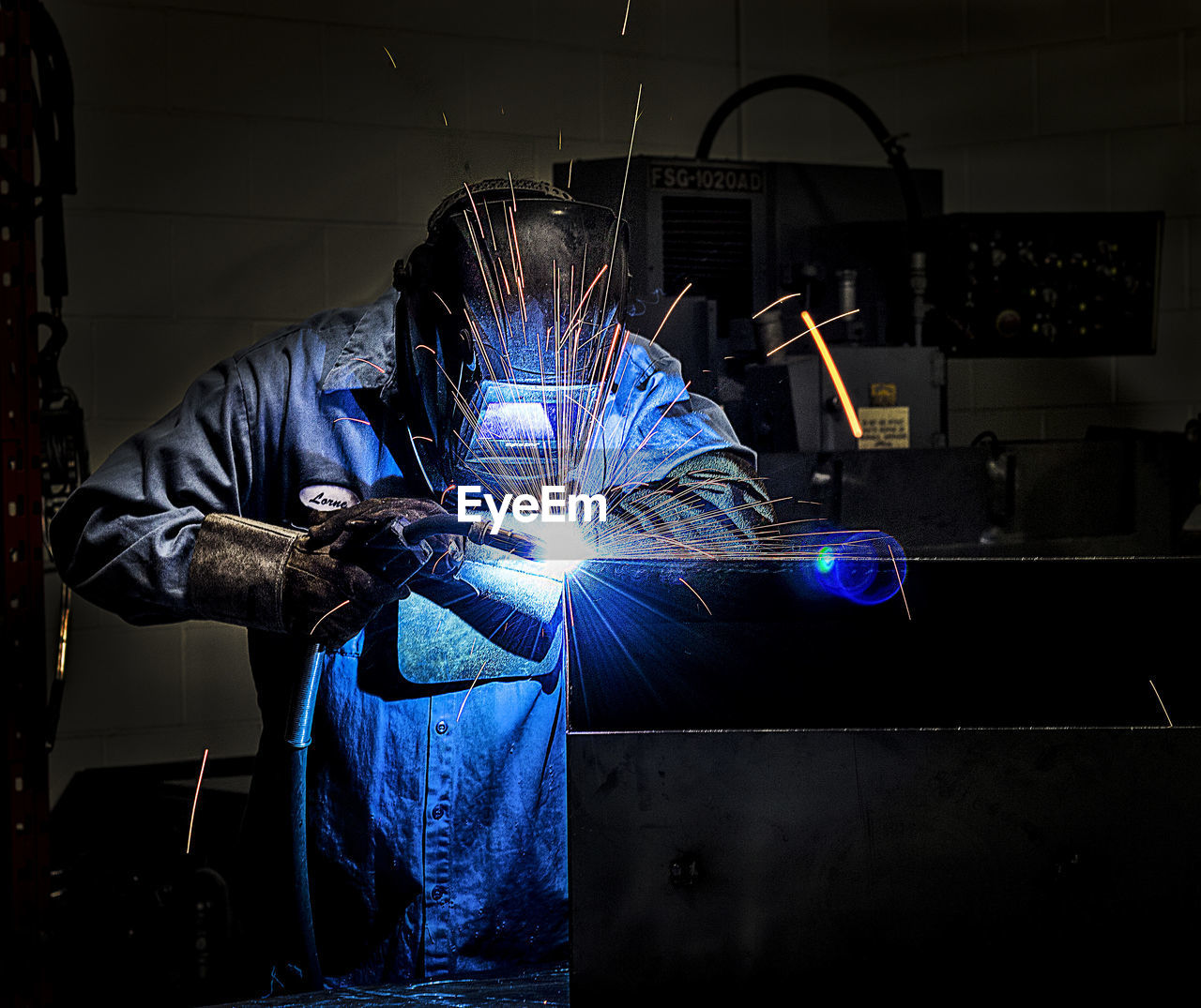 Welder welding metal in workshop