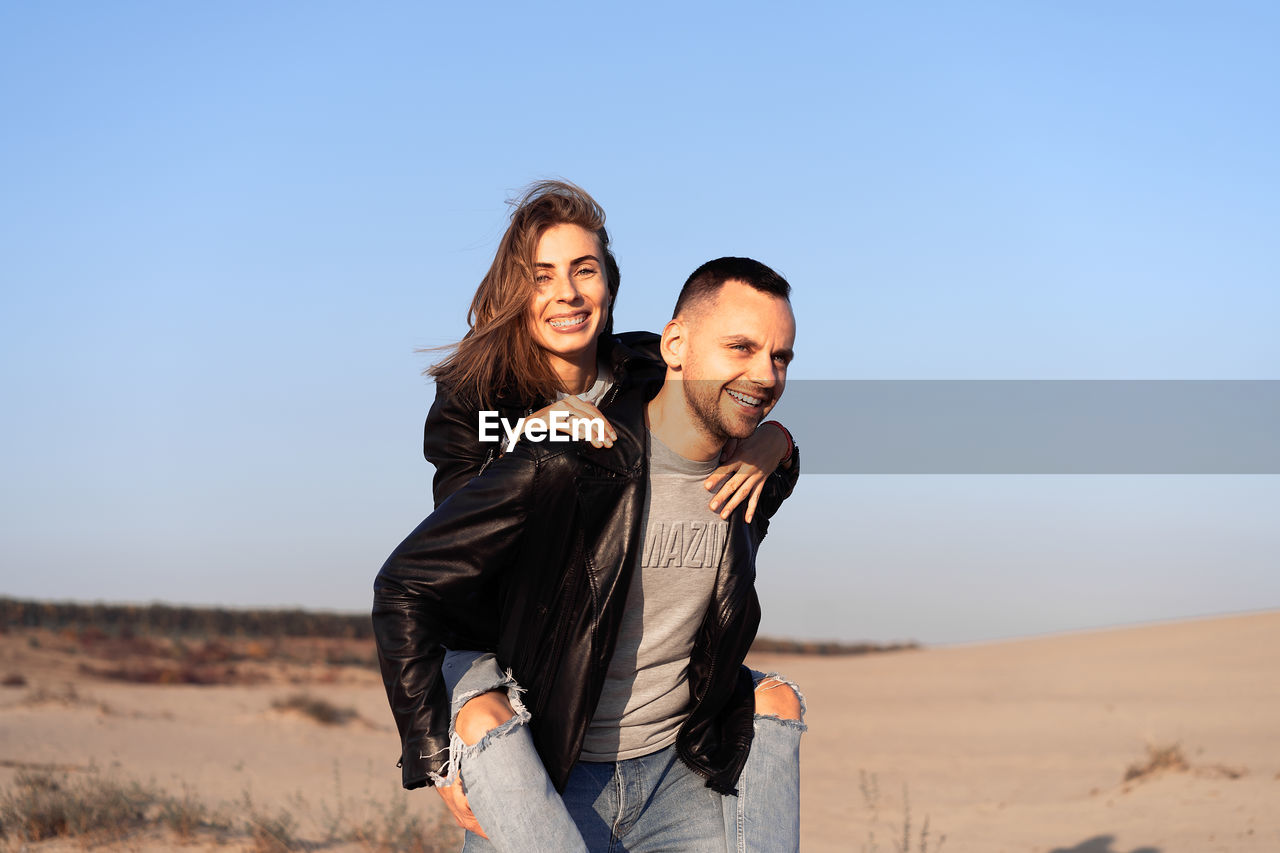 Young man giving his girlfriend a piggyback ride