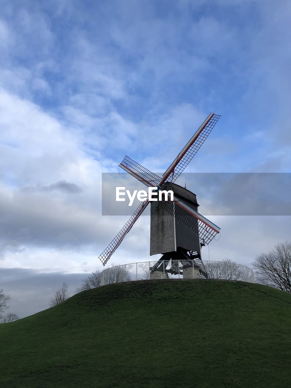 LOW ANGLE VIEW OF TRADITIONAL WINDMILL ON FIELD