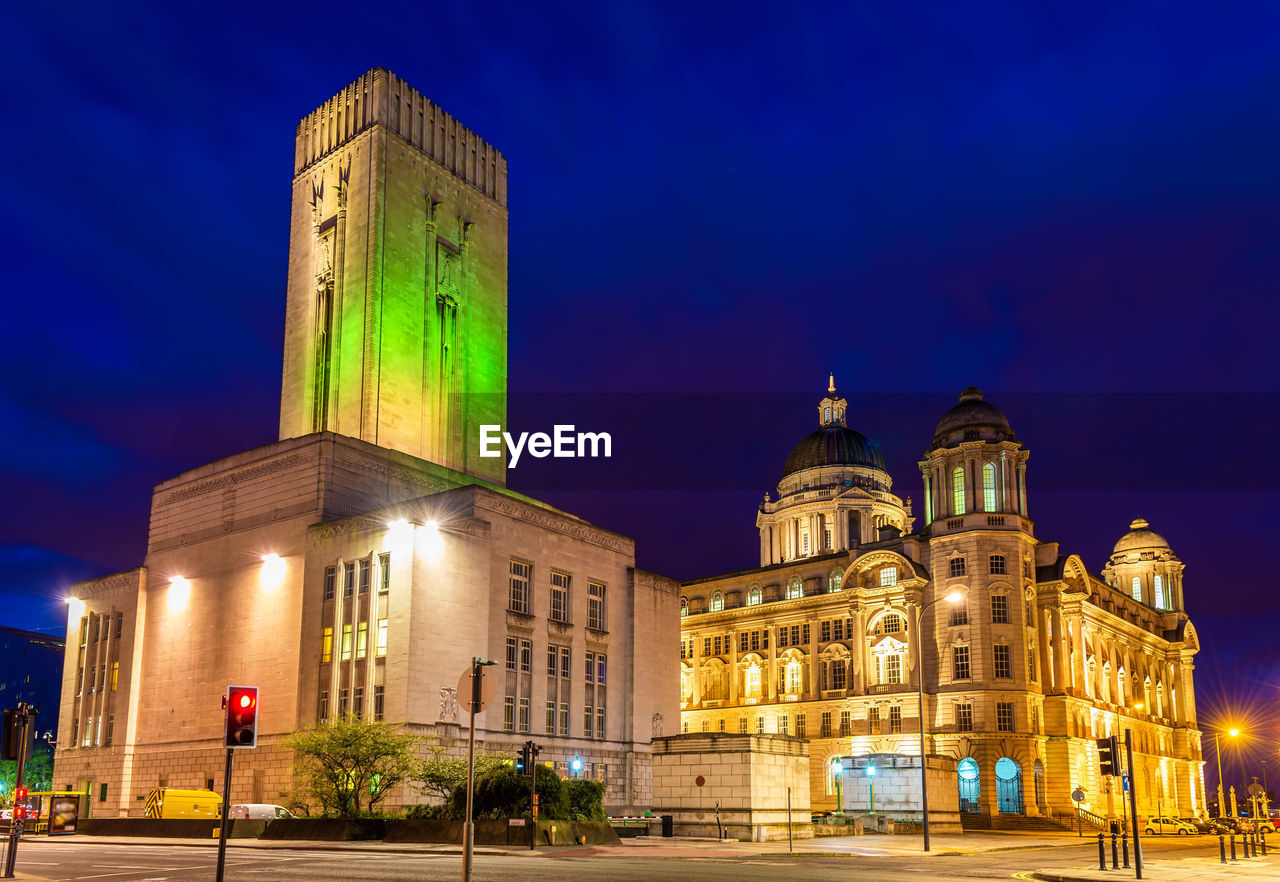 LOW ANGLE VIEW OF ILLUMINATED BUILDINGS AT NIGHT