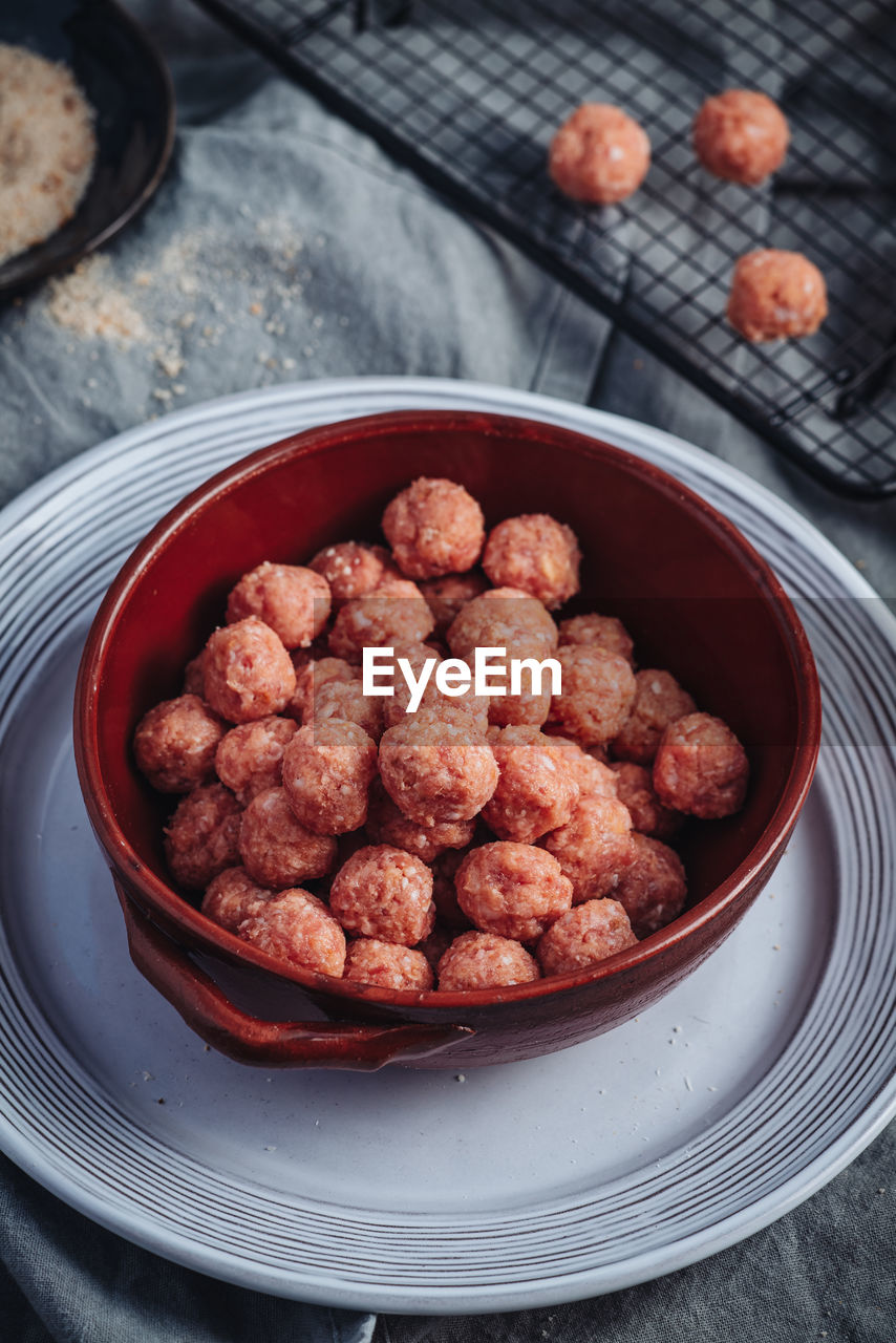 HIGH ANGLE VIEW OF RASPBERRIES IN BOWL ON TABLE