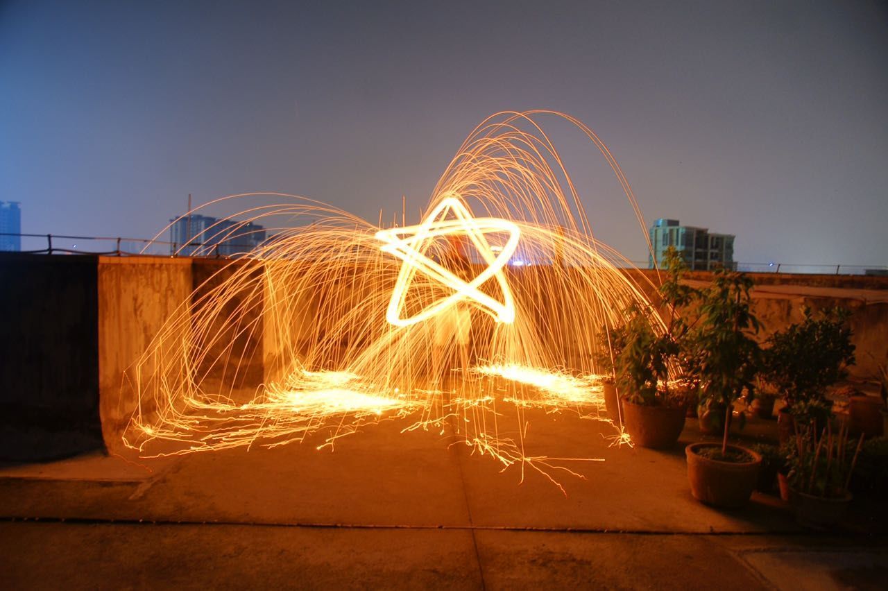 Light trails on road against sky at night