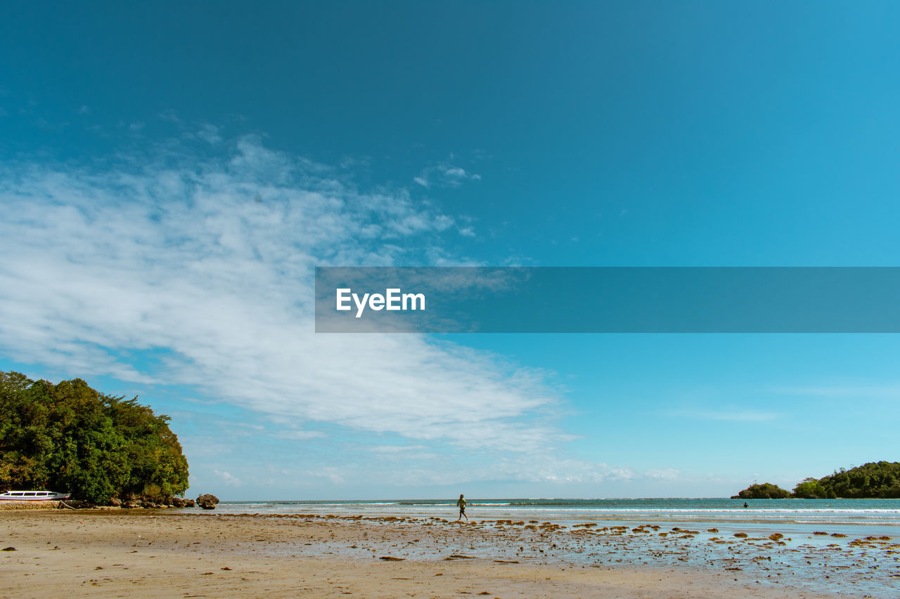 Scenic view of beach against blue sky