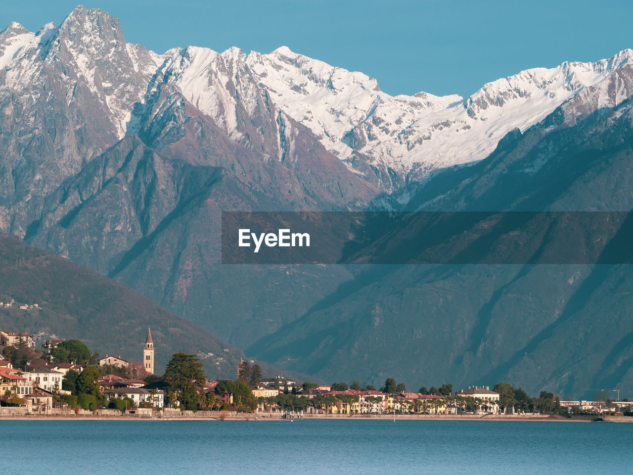 Scenic view of sea and snowcapped mountain against sky