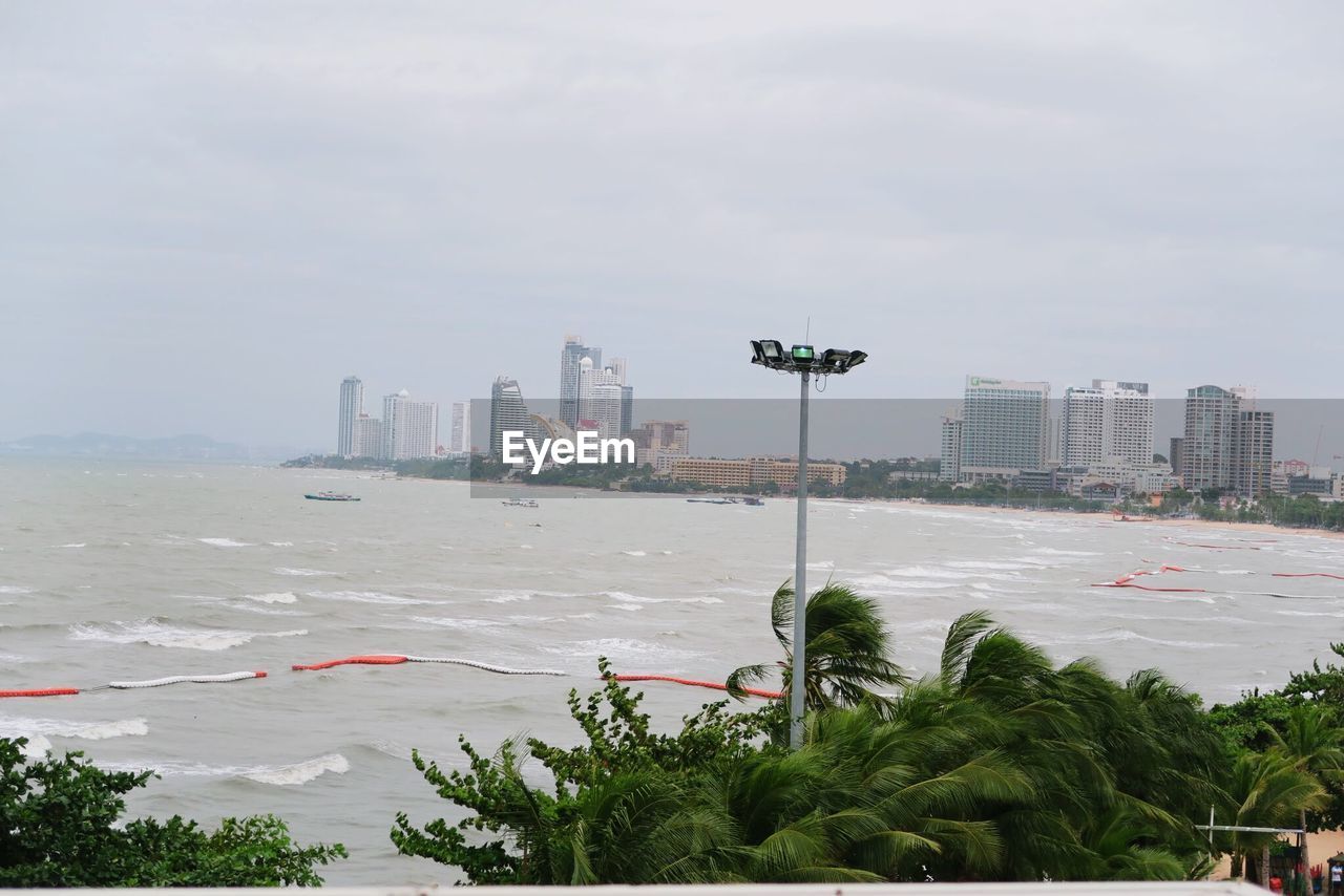 Buildings by sea against sky in city