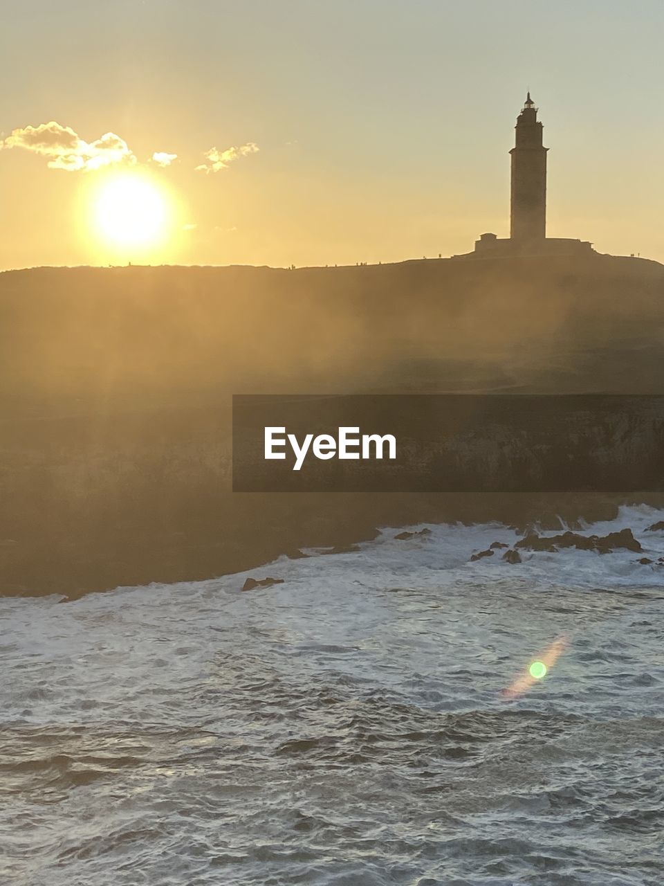 Scenic view of sea by buildings against sky during sunset